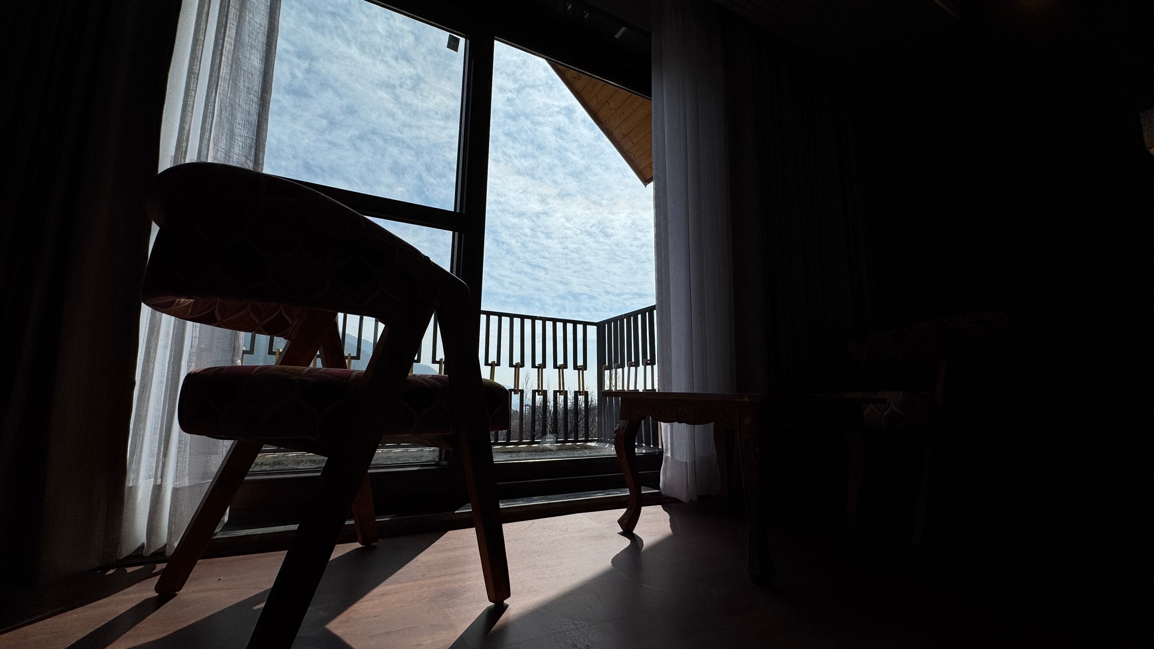 Dramatic silhouette view through balcony doors overlooking the valley