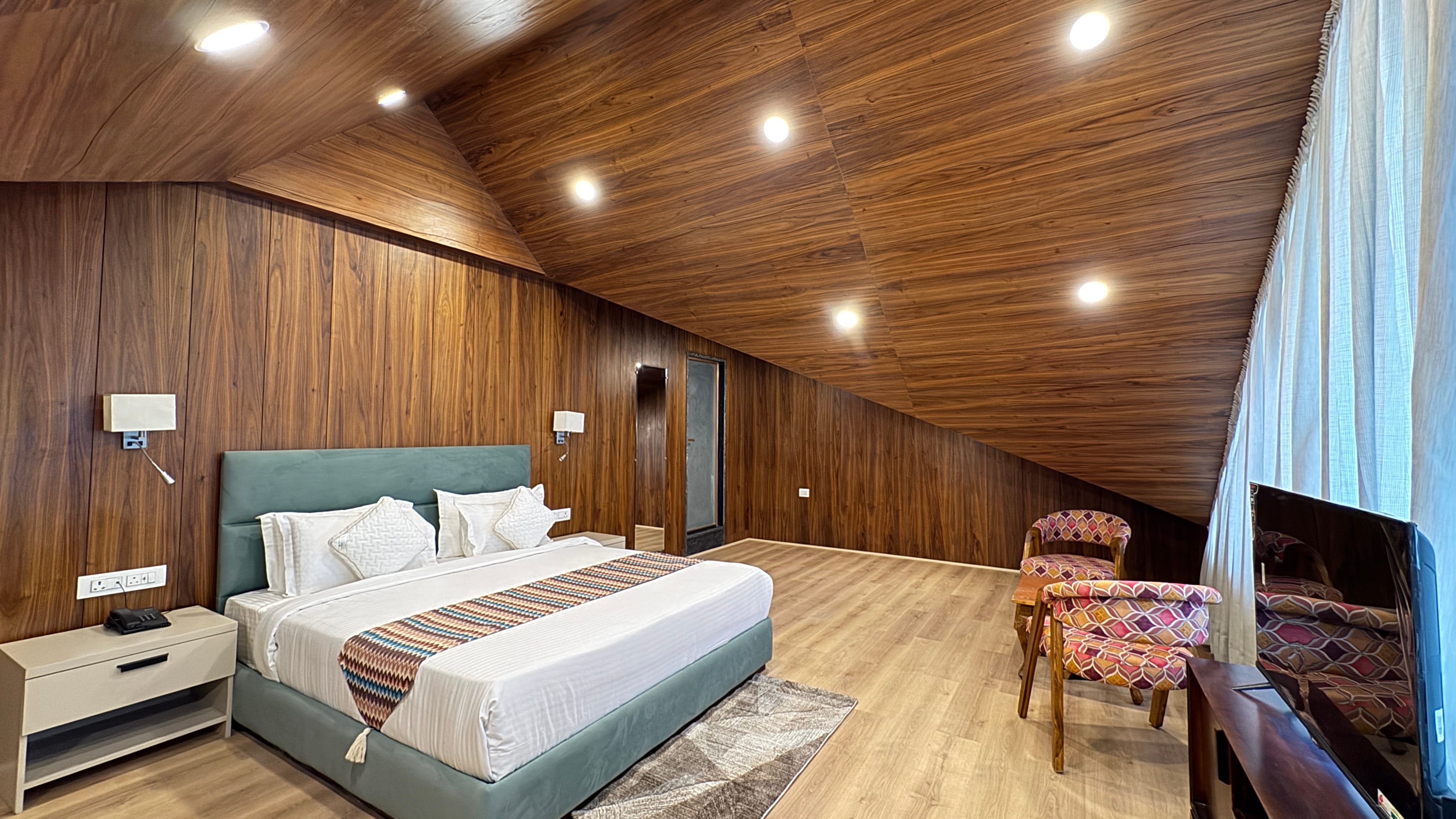Charming attic room with green headboard and warm wooden wall panels