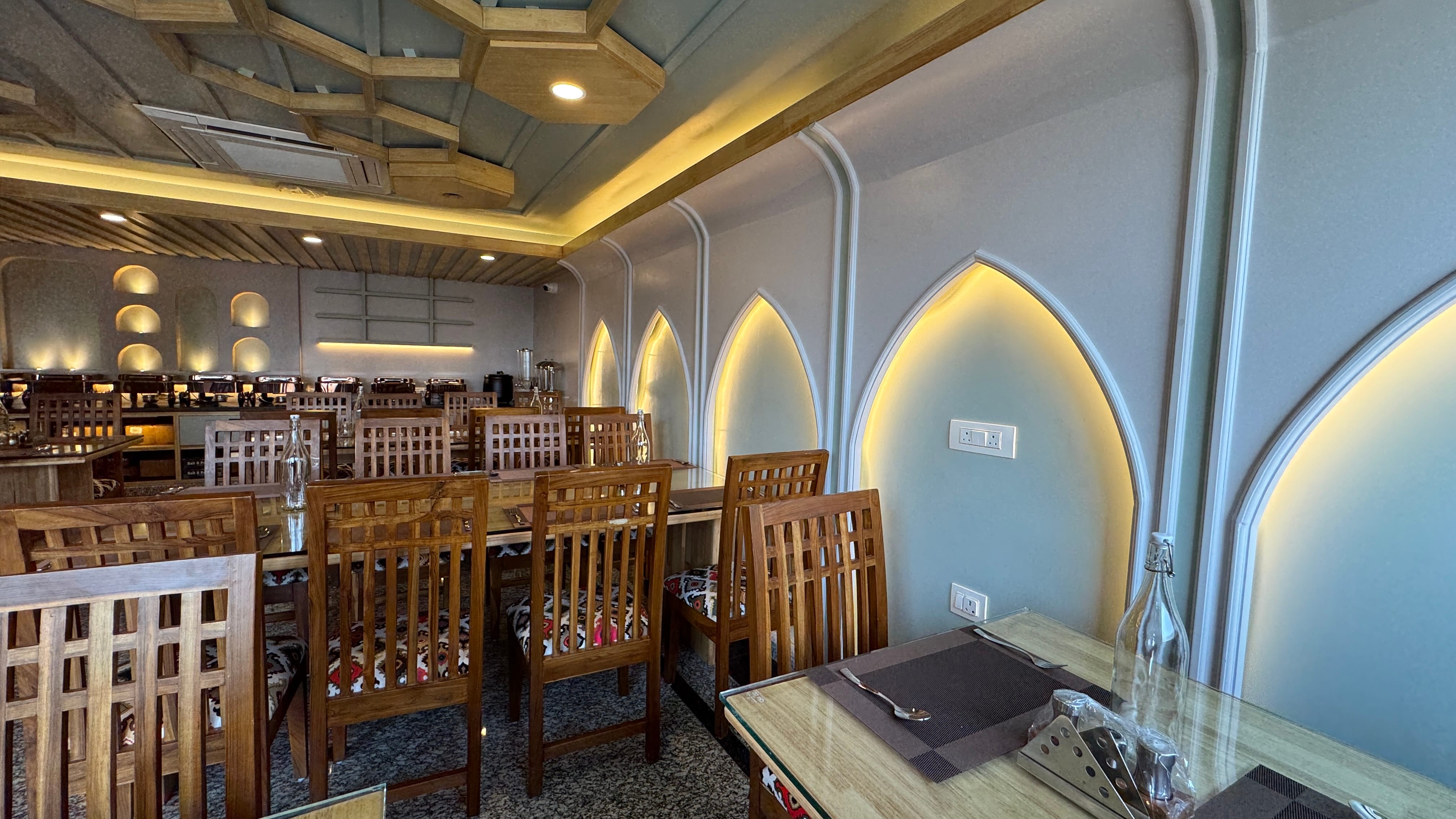 Restaurant interior with traditional Kashmiri arch details and warm lighting